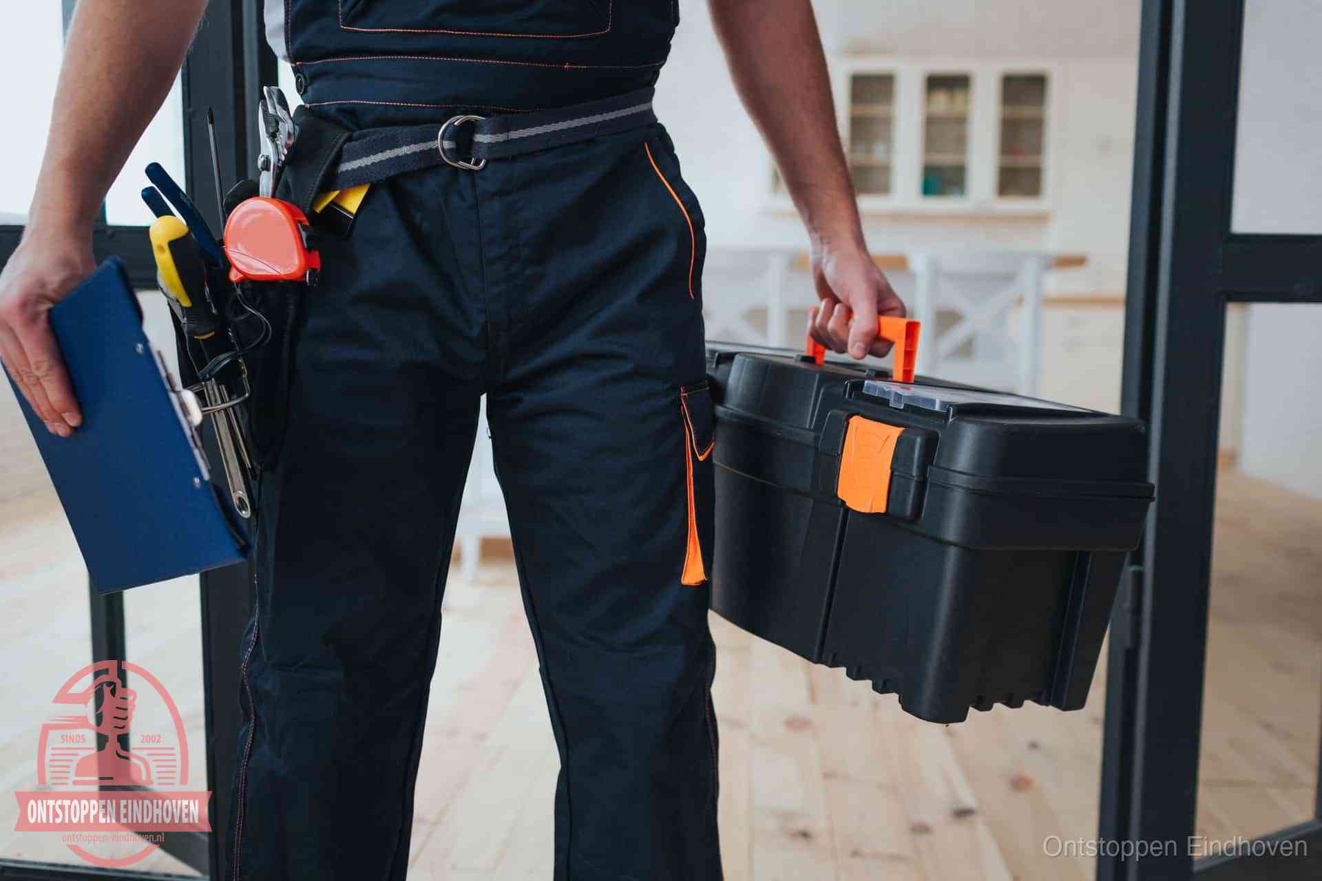 Een monteur met gereedschapsriem en klembord, klaar om een transparante prijs voor het wc ontstoppen in Eindhoven te geven Een monteur met gereedschapsriem en klembord, klaar om een transparante prijs voor het wc ontstoppen in Eindhoven te geven