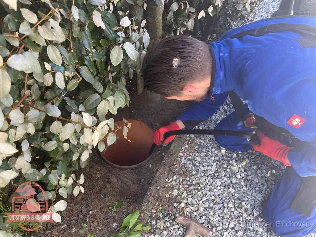 Monteur reinigt een rioolput met een slang, periodieke rioolreiniging in Eindhoven