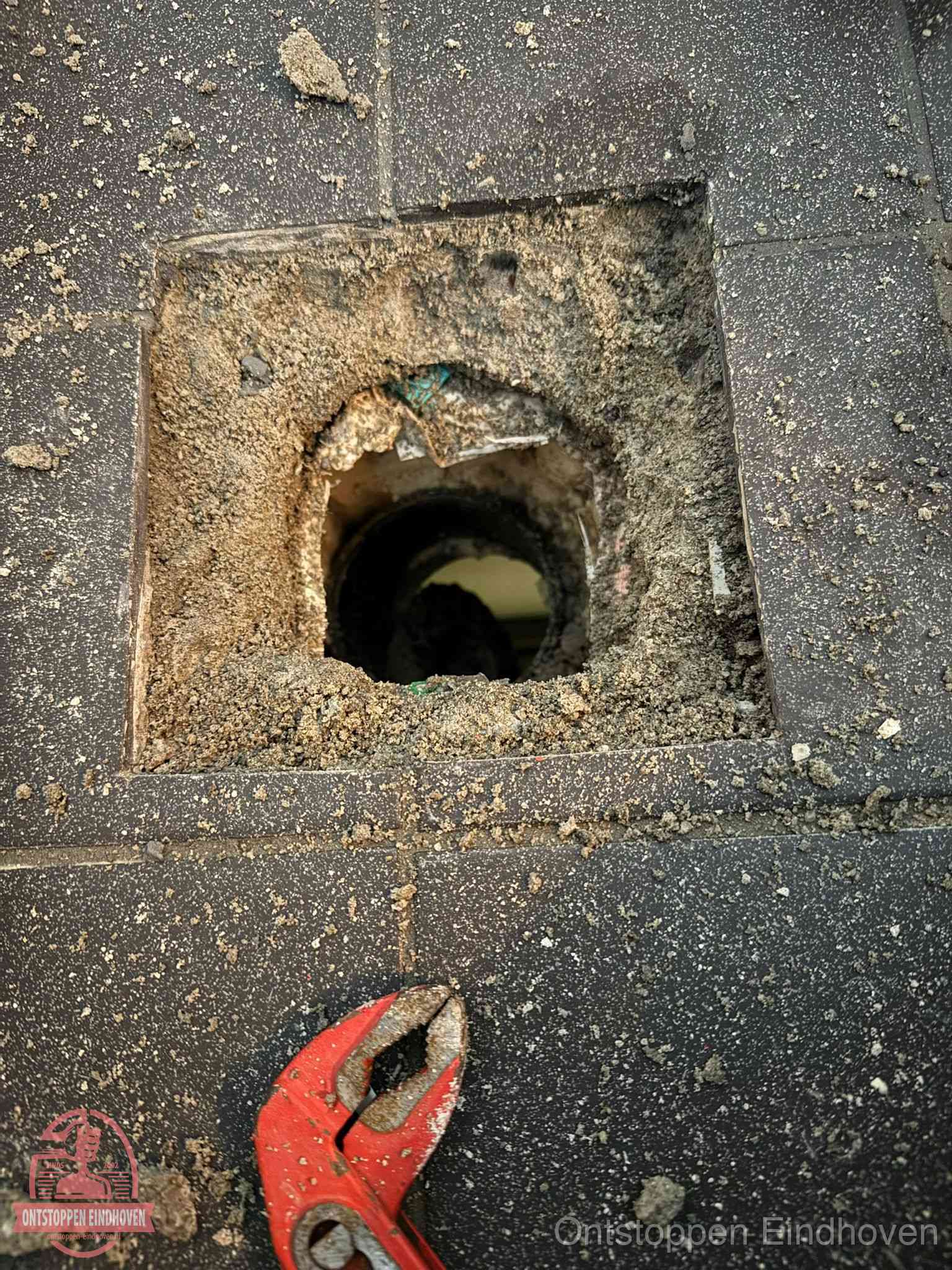 Geopend rioolputje op de erfgrens dat laat zien wie eigenaar is van de riolering in Eindhoven
