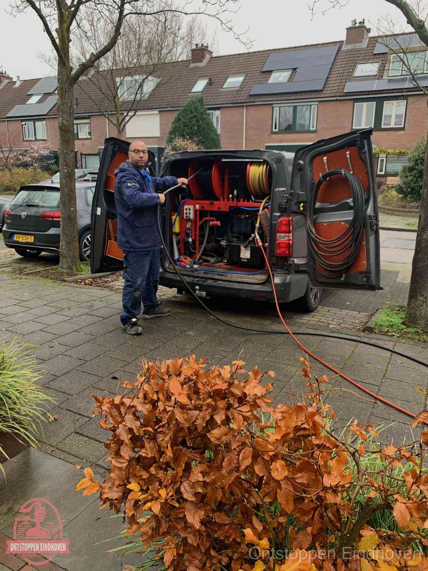 Monteur met rioolreinigingsbus levert rioolservice in de wijk in Eindhoven