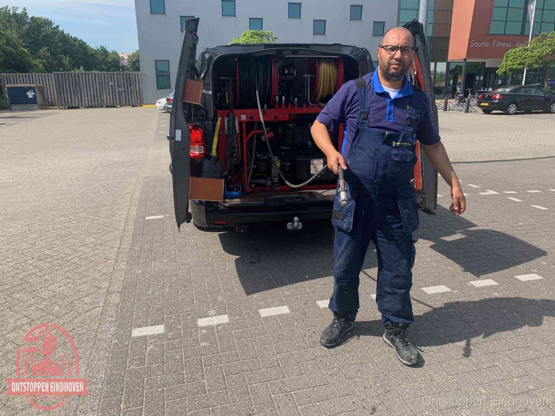 Een monteur bij zijn bestelbus met een hogedruk- en rioolreinigingsunit, klaar om de oorzaak van terugkerende wc-verstoppingen aan te pakken in Eindhoven Een monteur bij zijn bestelbus met een hogedruk- en rioolreinigingsunit, klaar om de oorzaak van terugkerende wc-verstoppingen aan te pakken in Eindhoven