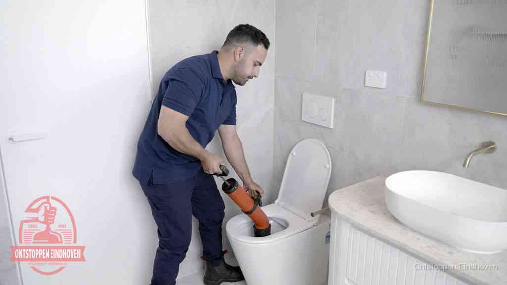 Een monteur gebruikt een handmatige perspomp (toiletontstopper) op een wandcloset tijdens het professioneel wc ontstoppen in Eindhoven Een monteur gebruikt een handmatige perspomp (toiletontstopper) op een wandcloset tijdens het professioneel wc ontstoppen in Eindhoven